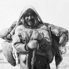 Photo d'une famille inuite voyageant par voie de terre en été à la baie d'Hudson, Chesterfield Inlet (Igluligaarjuk), Nunavut, 1912 ou 1916