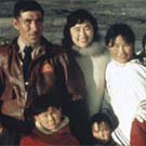 Photograph of a group of Inuit consisting of a man, women and children on the deck of an Eastern Arctic expedition ship, unknown location, Nunavut, 1958