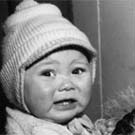 Photograph of a young Inuit woman holding her crying infant, Iqualuit (formerly Frobisher Bay), Nunavut, circa 1950s