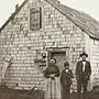 Photograph of a family in front of their home, Whycocomagh, Nova Scotia, 1911