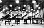 Photo de Glenn Gould jouant sur l'un des quatre pianos de concert disposés l'un à côté de l'autre